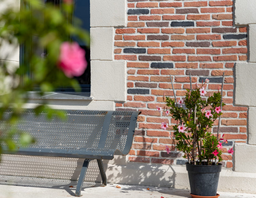 Banc et pot de fleur proche d'un mur recouvert de parement Brique 5 tons ORSOL